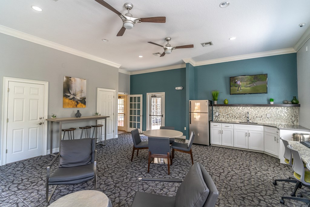 a room with a table and chairs and a kitchenette