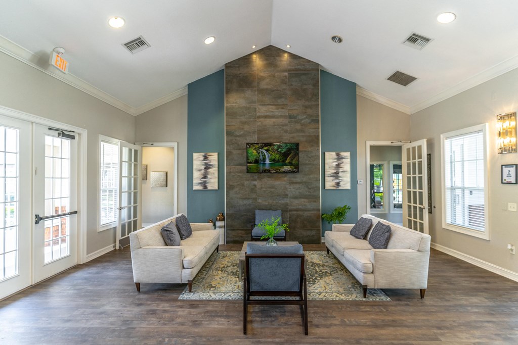 a clubhouse room with couches chairs tv and a coffee table