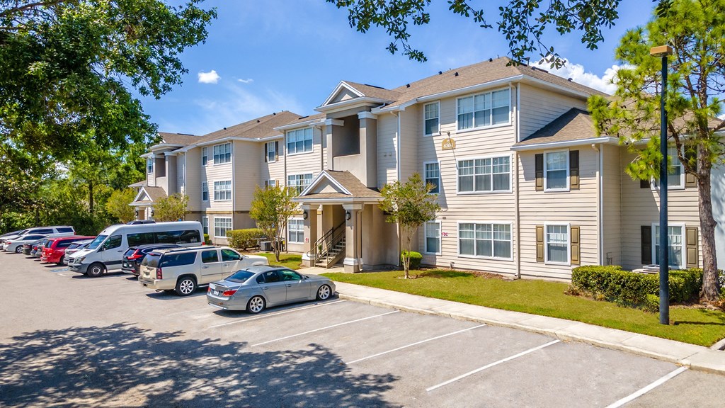 a large apartment building with a parking lot in front of it