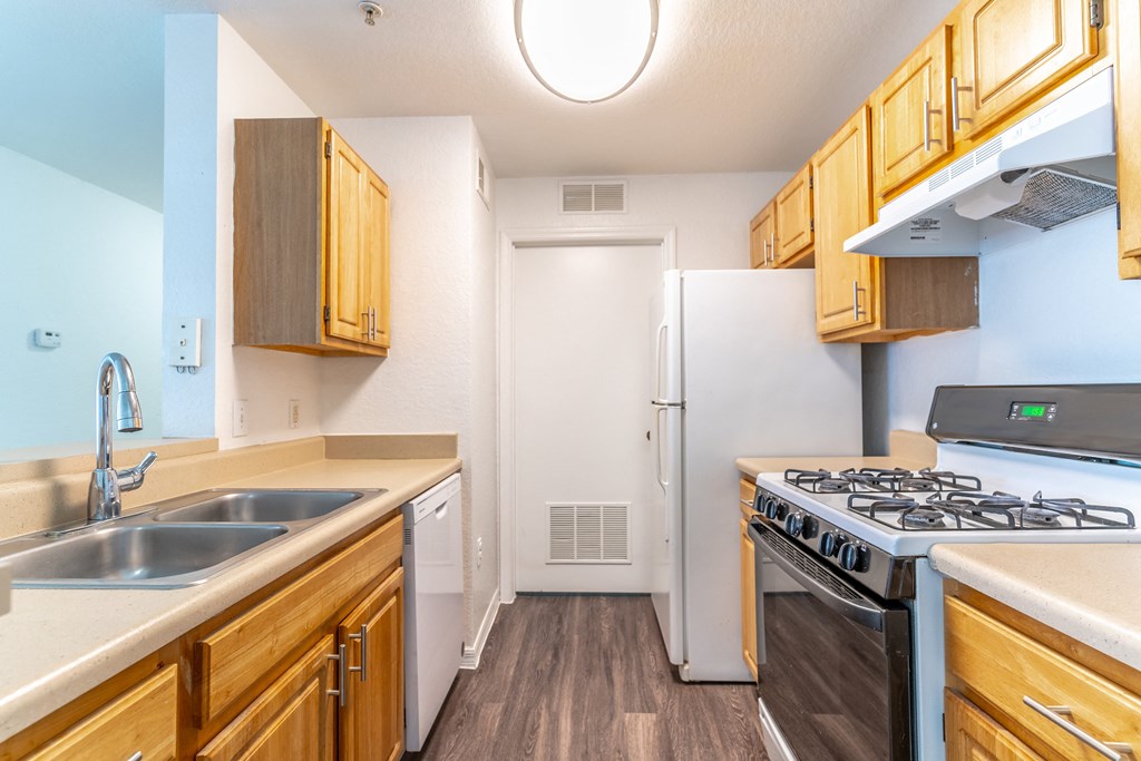a kitchen with wood cabinets and white appliances