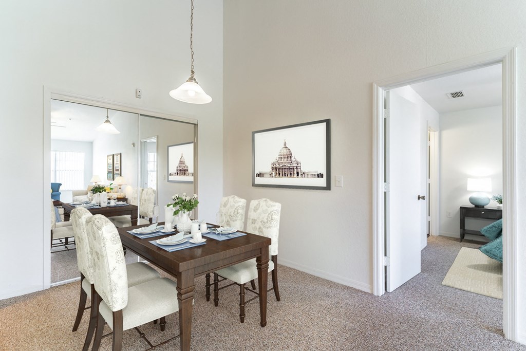 a dining room with a wooden table and white chairs