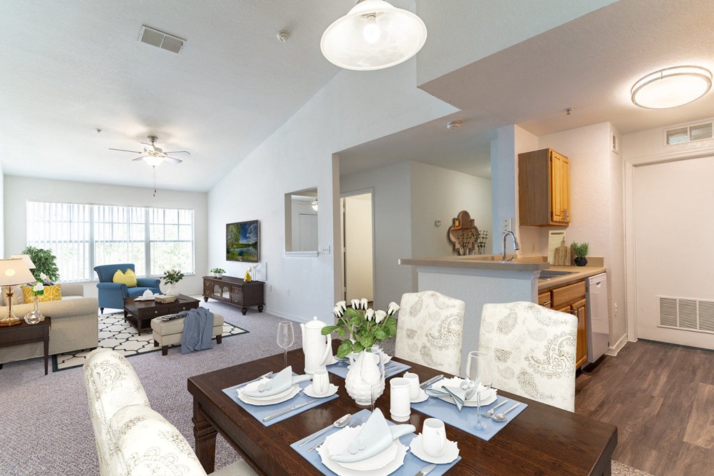 a living room with a dining table and a kitchen in the background