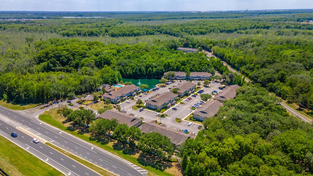 an aerial view of a large apartment complex with a lake in the background