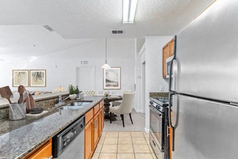 a kitchen with a stainless steel refrigerator and a sink