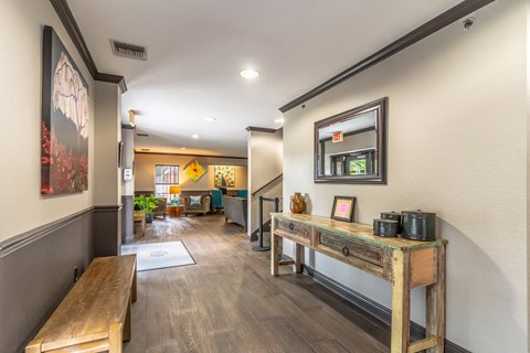a hallway with benches and a table with a coffee pot on it