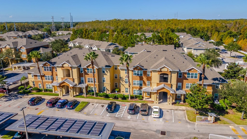 an aerial view of a large apartment complex with cars parked in the parking lot