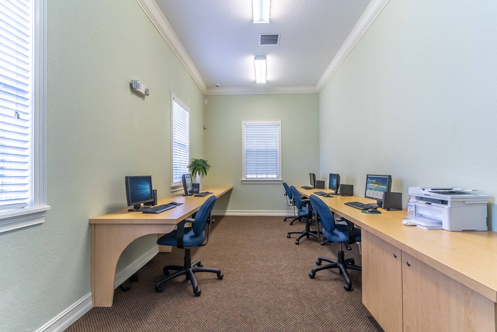 a computer lab with four computers and a printer