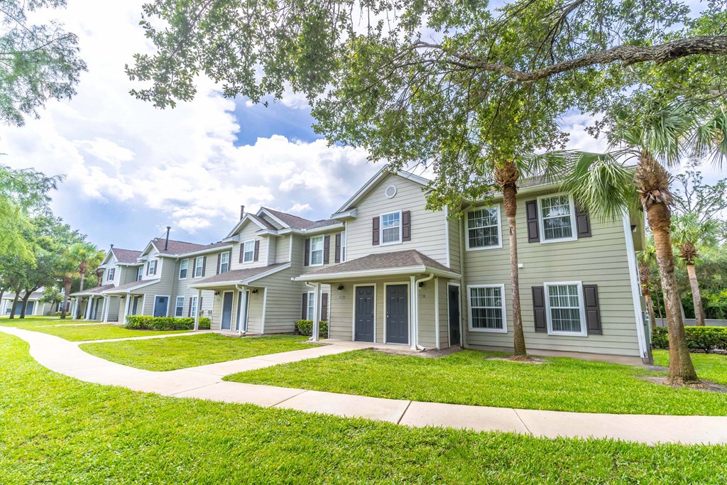 a row of townhomes with trees in front of them