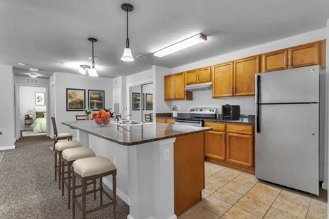 a kitchen with a counter top island and a refrigerator