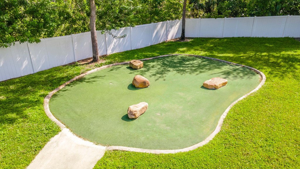 a mini golf court with rocks in the grass