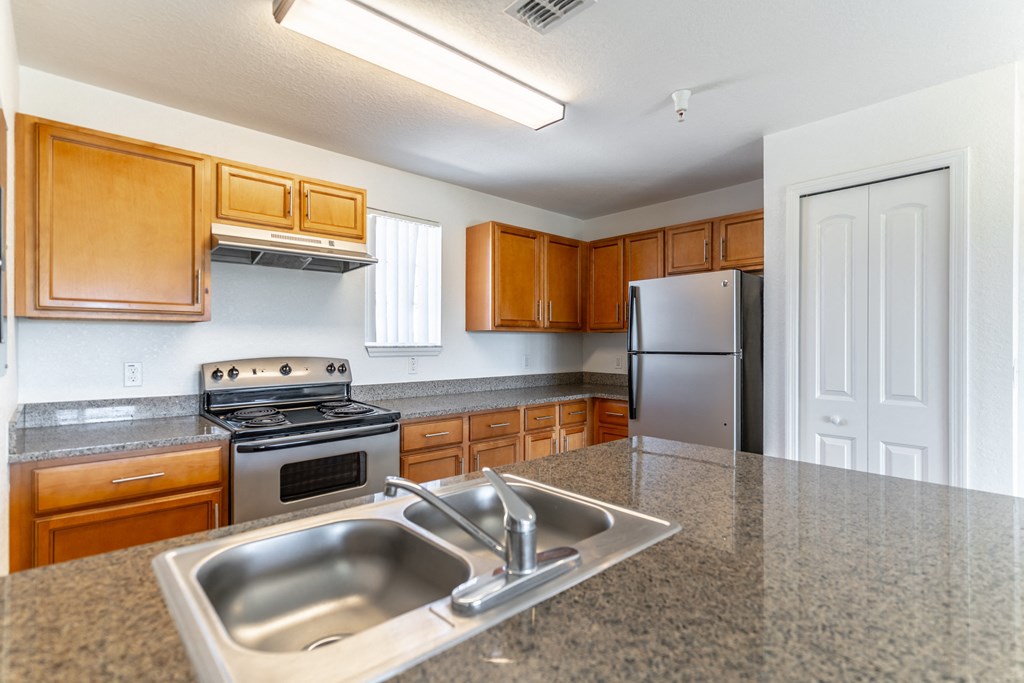 a kitchen with granite countertops and wooden cabinets
