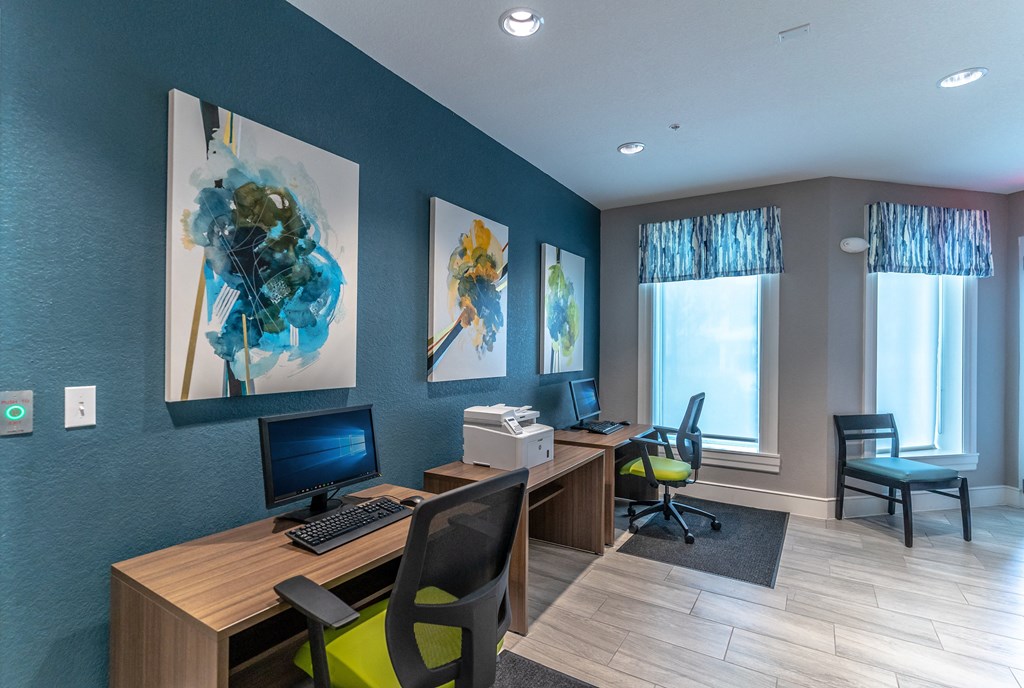 business center with two computers, chairs, and a printer