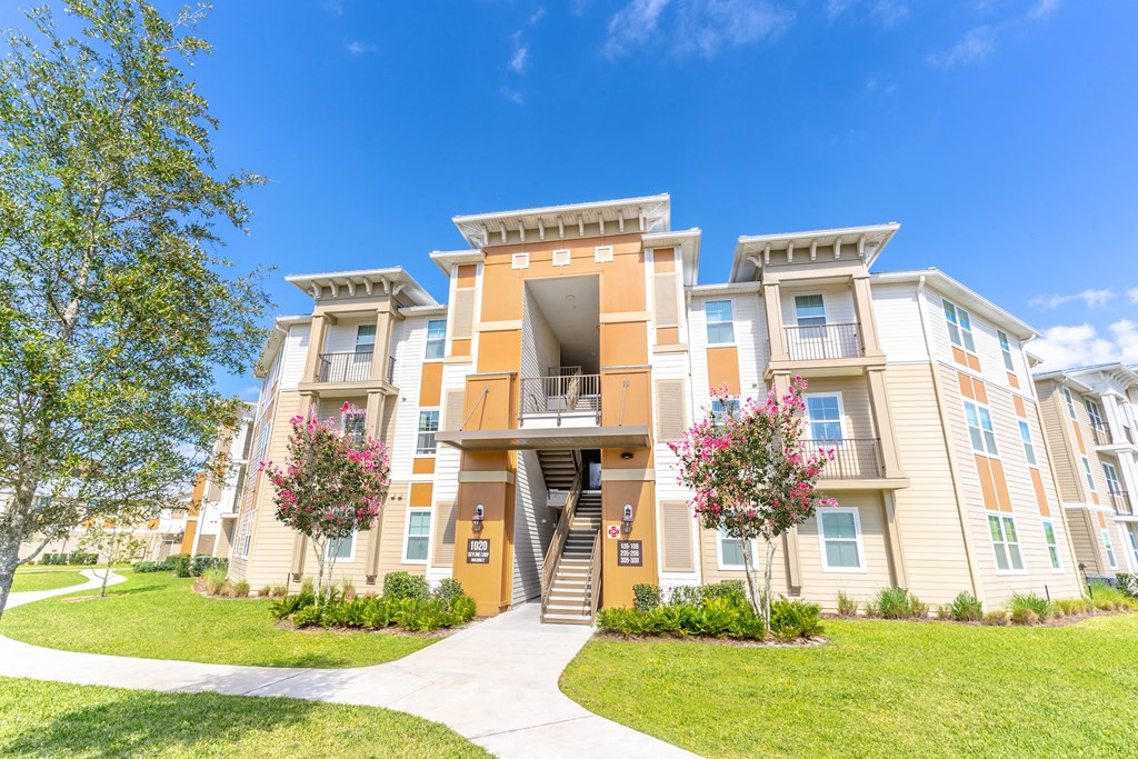 an apartment building with a sidewalk in front of it