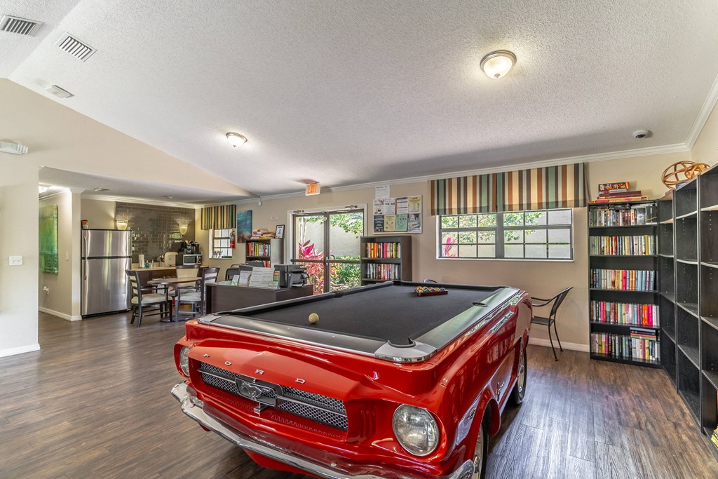 a game room with a pool table and bookshelves