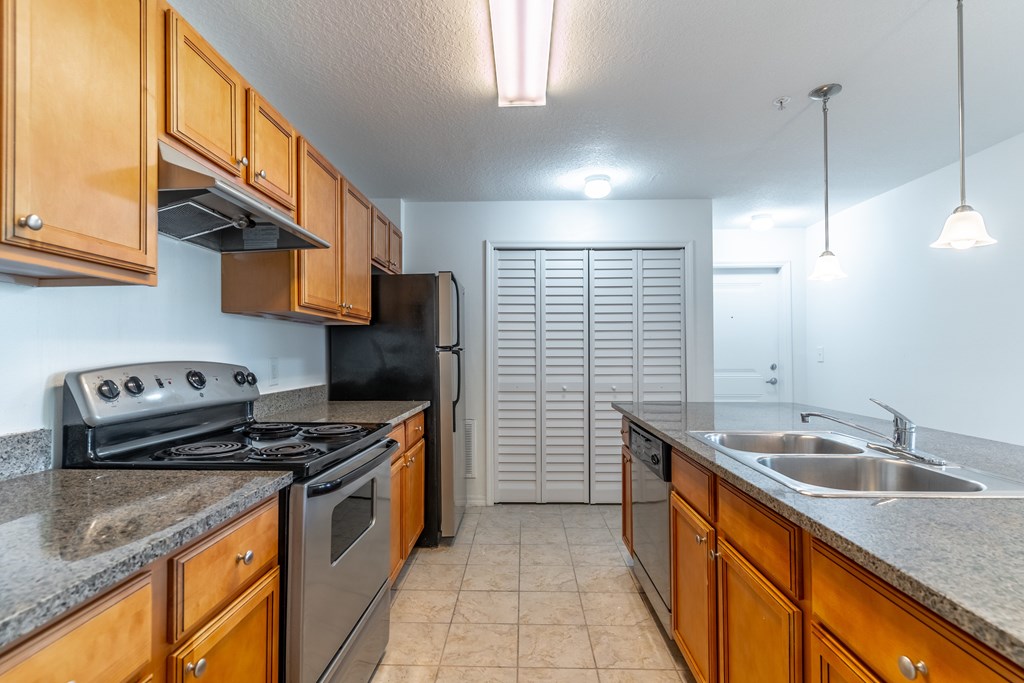 A kitchen with wooden cabinets and a black stove top oven.