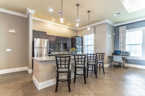 a kitchen with a bar and a table with chairs