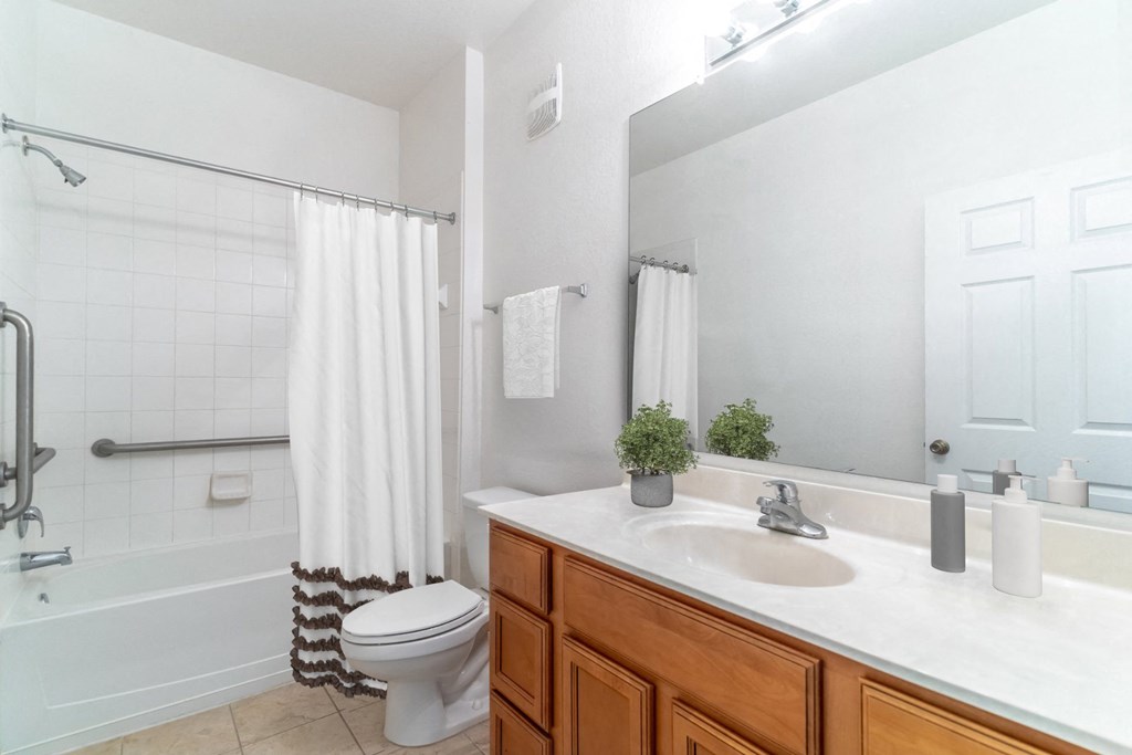 a bathroom with a white toilet next to a bathtub with a shower curtain