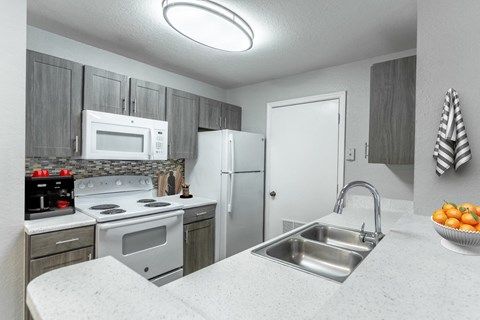 a kitchen with white appliances and granite counter tops