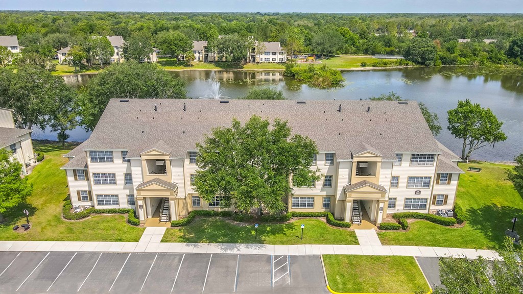 an aerial view of an apartment building a lake in the background