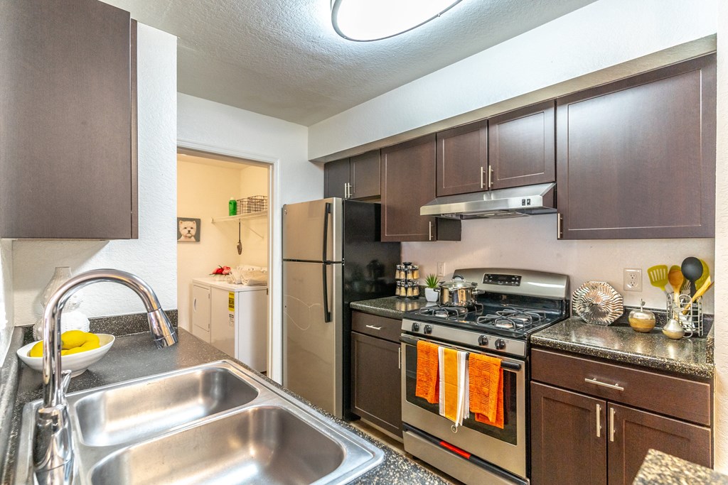 a kitchen with brown cabinets and stainless steel appliances