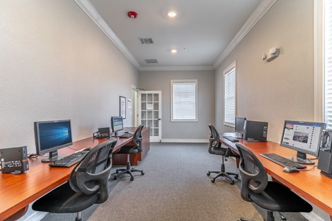 three computers in a room with a door in the background
