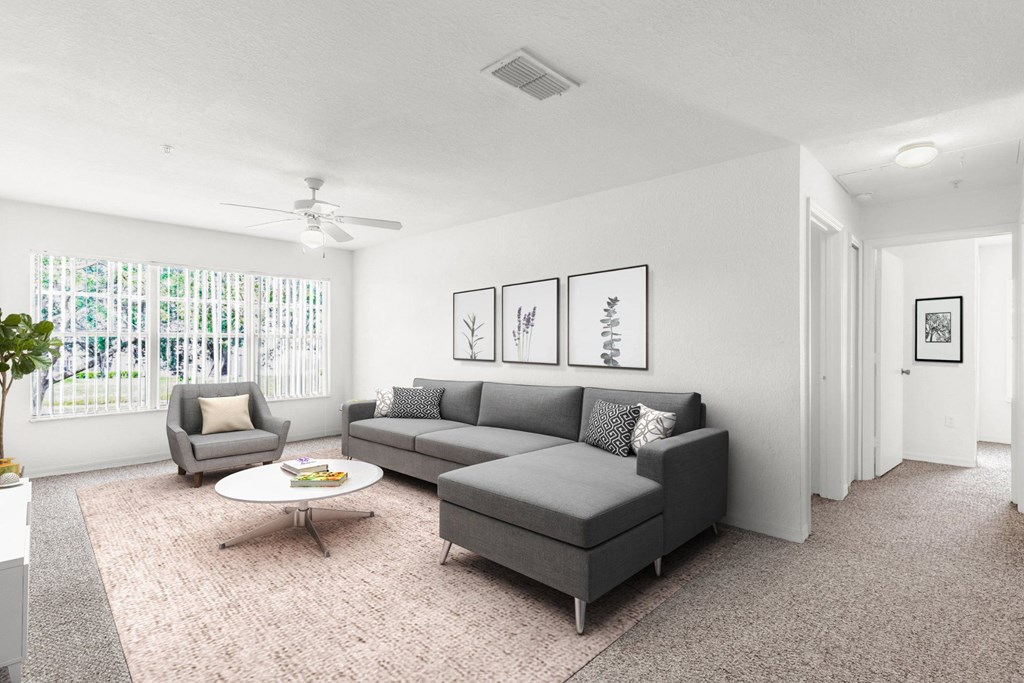 a living room with a couch coffee table and a ceiling fan