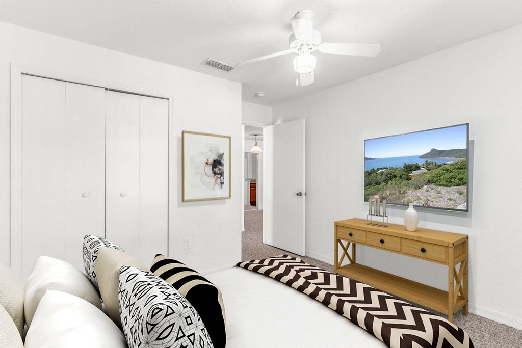 a bedroom with a large bed and a ceiling fan