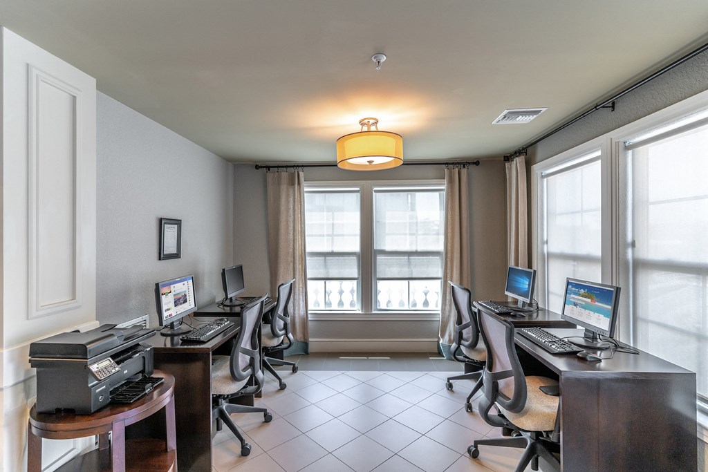 a computer room with several computers on the desks and a printer on a table