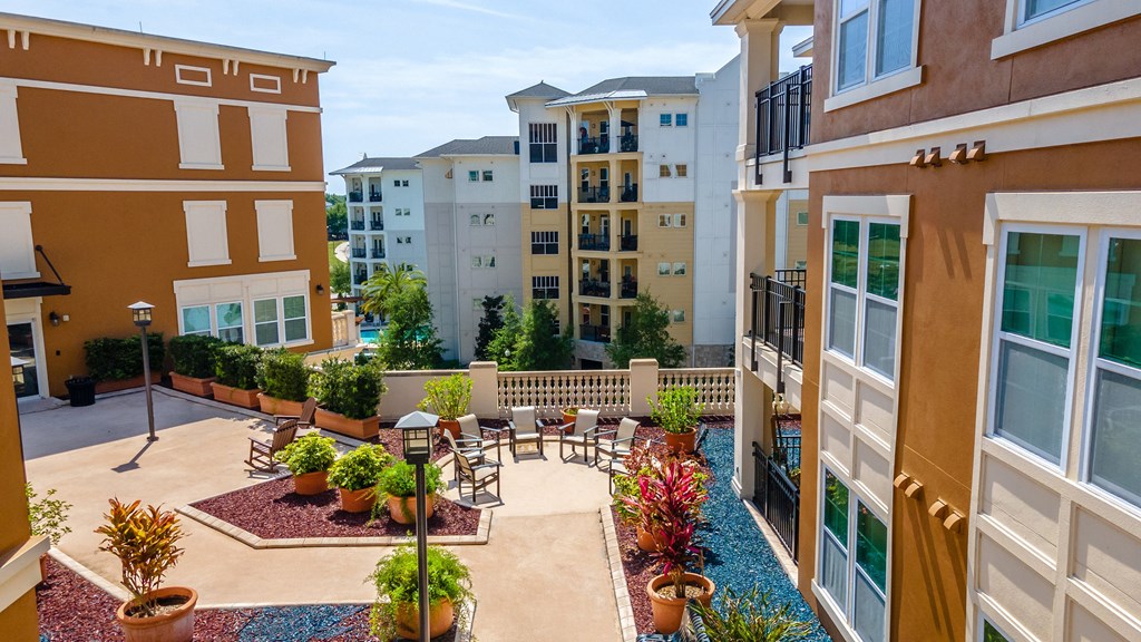 a courtyard with a table and chairs and potted plants