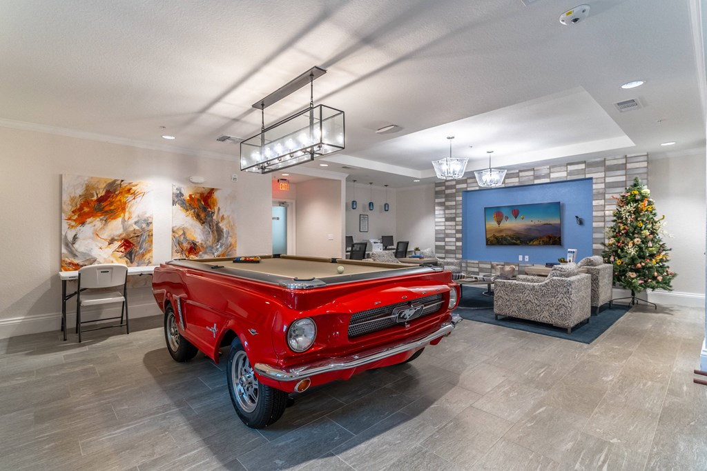a red pool table in a room with a christmas tree