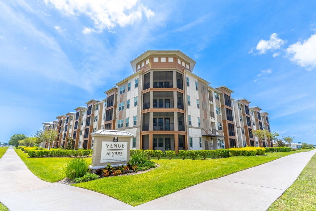 a large apartment building with a sidewalk in front of it