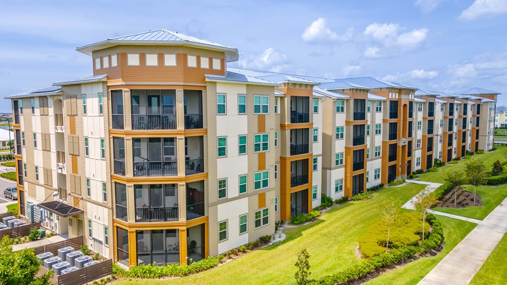 a large apartment complex with a grassy area in front of it