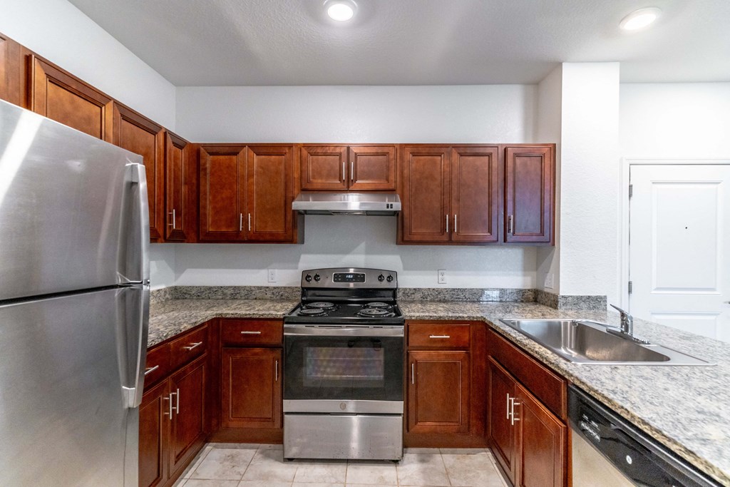 a kitchen with wooden cabinets and granite countertops