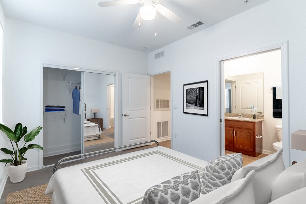 a bedroom with a large bed and a bathroom in the background