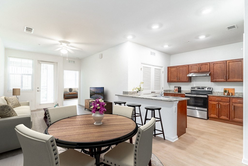 a kitchen and living room with white walls and wood flooring