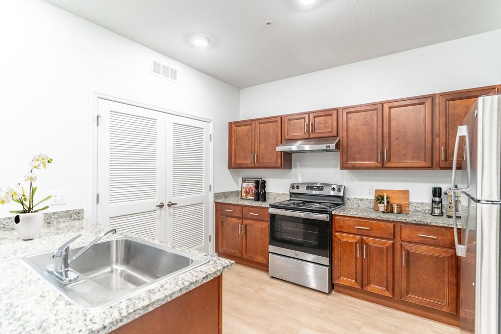 a kitchen with wooden cabinets and a stainless steel sink