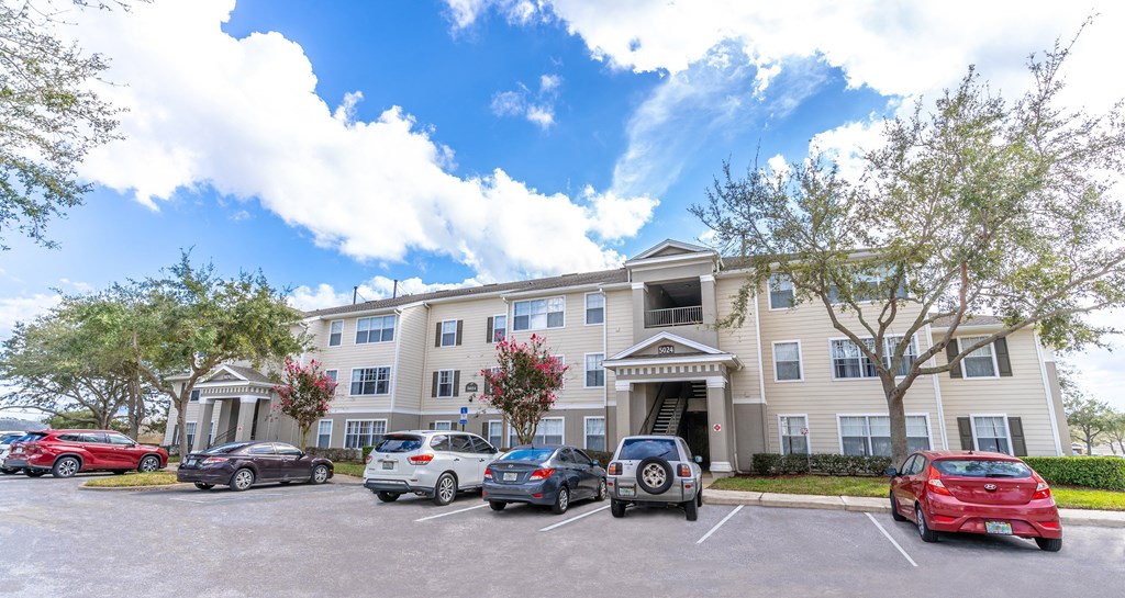 a large apartment building with a parking lot in front of it