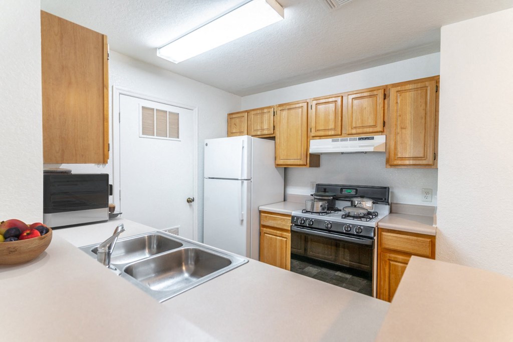 a kitchen with wooden cabinets and white appliances