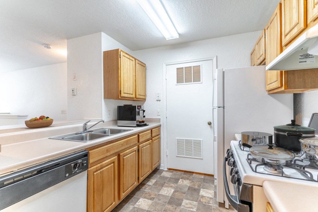 a kitchen with wooden cabinets and white appliances