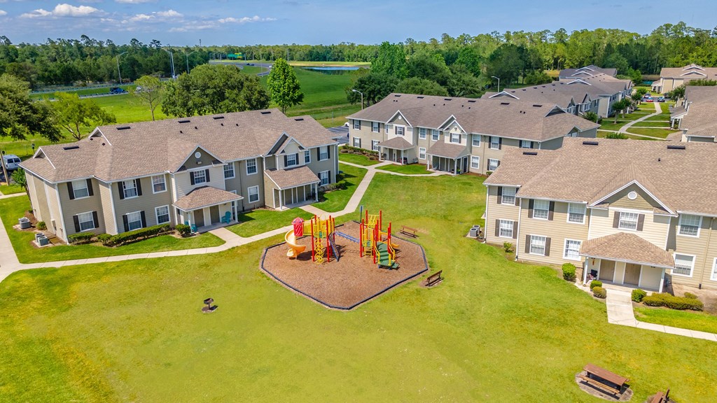 an aerial view of a playground in front of a row of houses