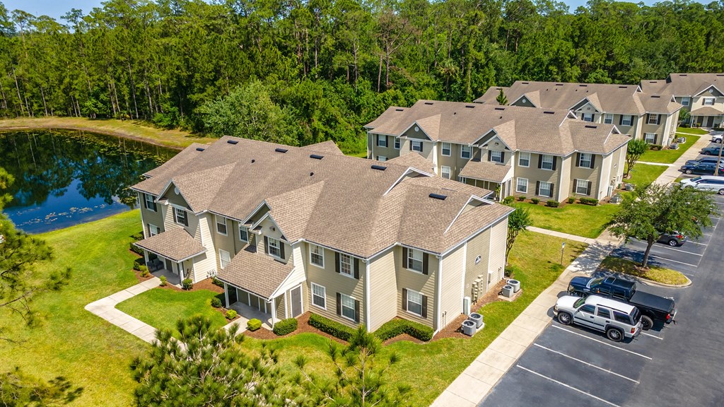 an aerial view of a row of apartment homes with a lake in the background