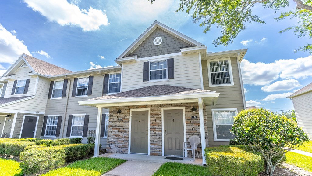 a house with a stone facade and gray siding