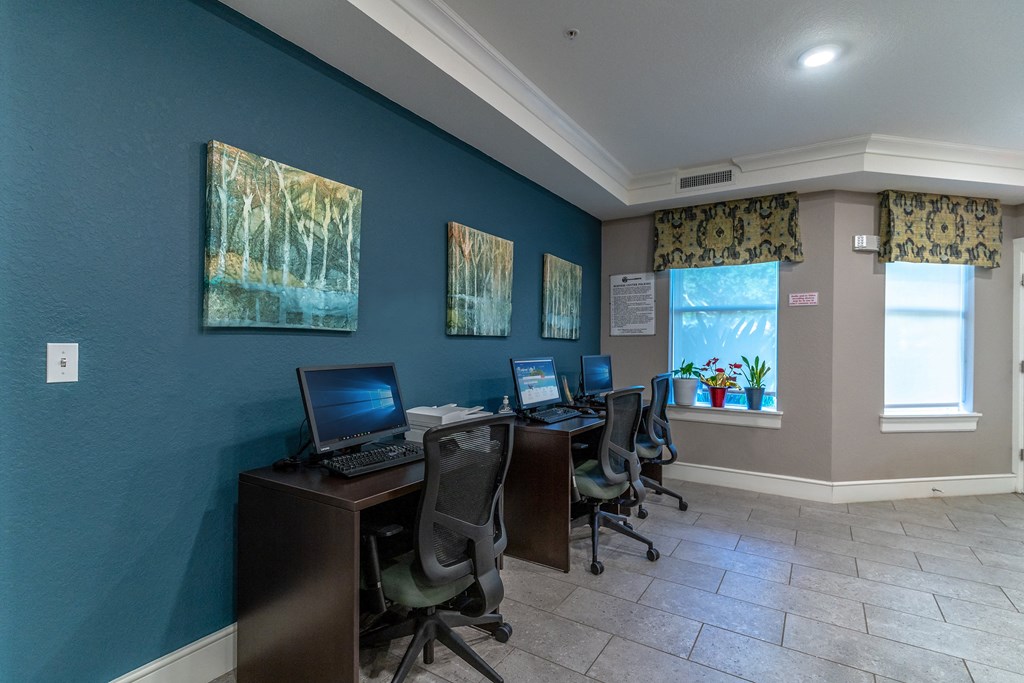 the business center with three computers and three chairs