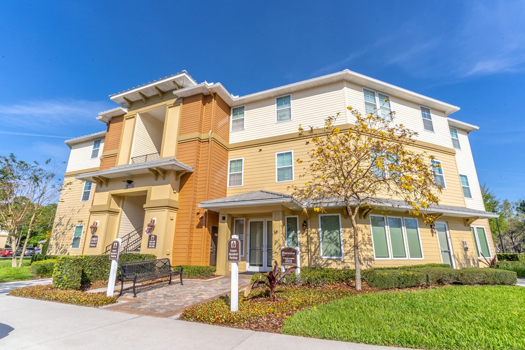 a large yellow building with a bench in front of it