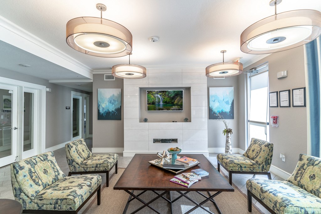 a clubhouse room with couches chairs tv and a coffee table
