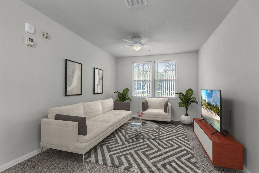 another view of a living room with a couch a coffee table and a tv