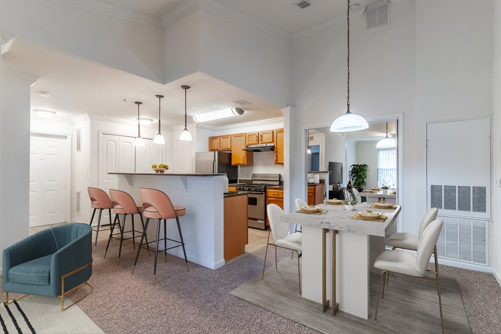 an open kitchen and living room with a dining table and chairs