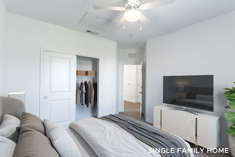 A living room with a grey couch and a television on a cabinet.