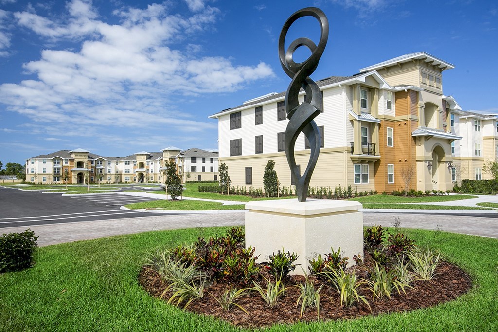 a statue in front of an apartment complex