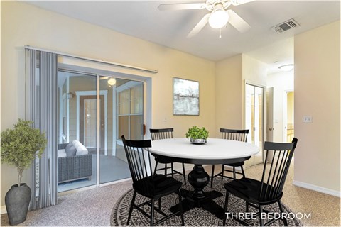 A dining room with a table and chairs.